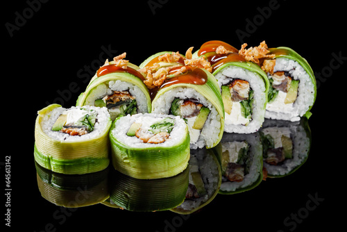sushi roll green dragon with eel avocado cucumber cream cheese on a black mirror background