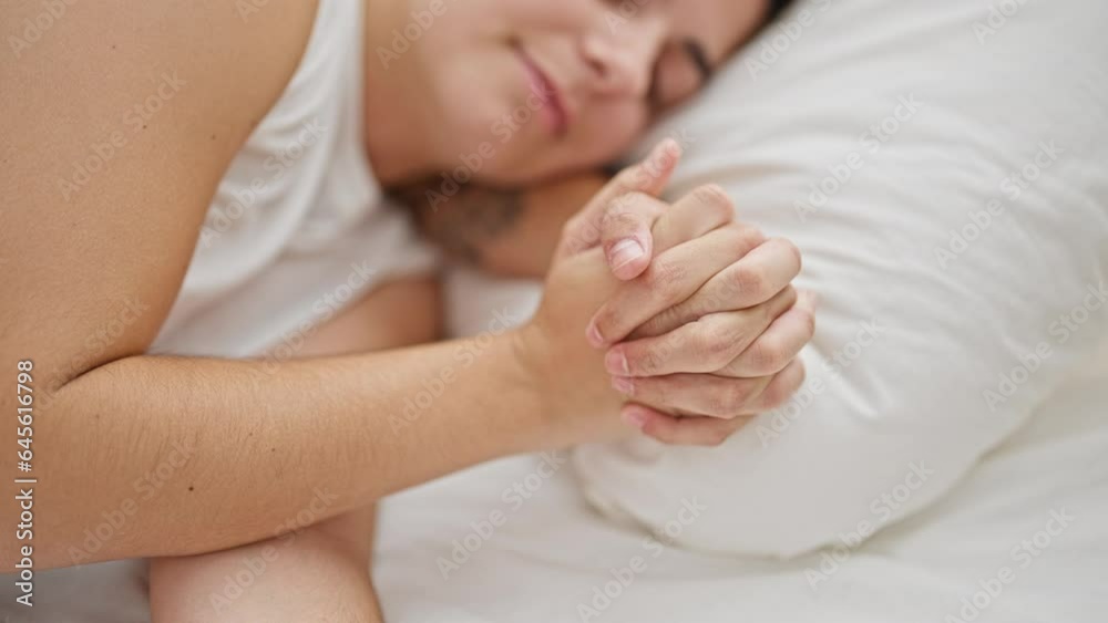 Beautiful couple lying on bed sleeping with hands together at bedroom Beautiful couple lying on bed sleeping with hands together at bedroom