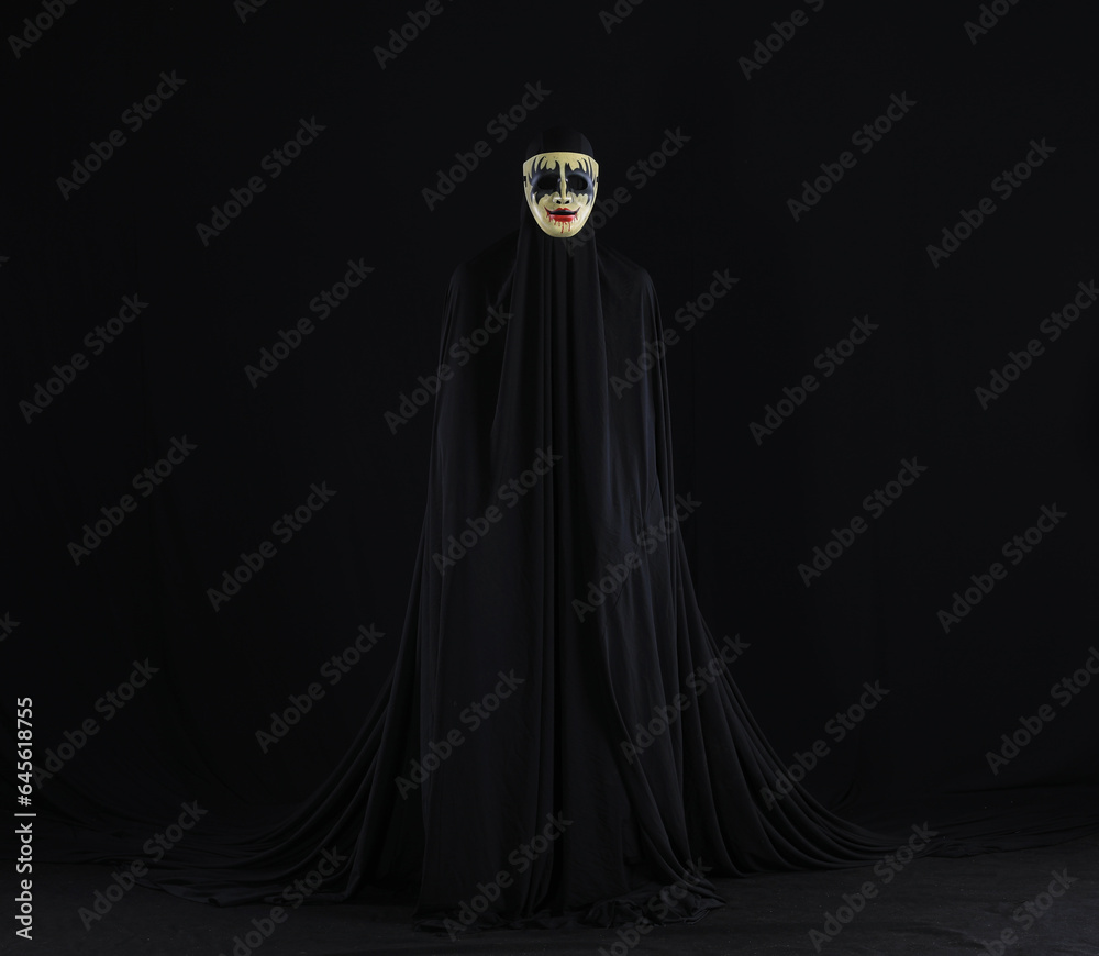 witch in a black cloak on a black background witch in a black cloak on a black background