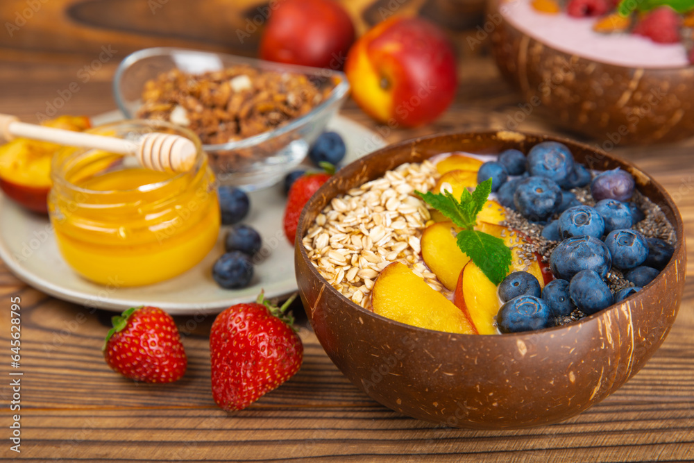 Bowl of granola with yogurt and fresh berries on a texture table. Yogurt berries, acai bowl, spirulina bowl. Healthy food, balanced breakfast. Strawberries, blueberries, kiwi, peach, almonds and chia. Bowl of granola with yogurt and fresh berries on a texture table. Yogurt berries, acai bowl, spirulina bowl. Healthy food, balanced breakfast. Strawberries, blueberries, kiwi, peach, almonds and chia.