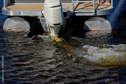 A running outboard motor on a boat in the water. photo