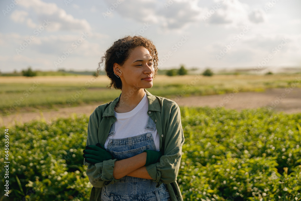 Woman agronomist with crossed hands standing on potato field background. Agriculture concept Woman agronomist with crossed hands standing on potato field background. Agriculture concept