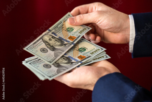 businessman pay amount of money, holding dollars 
