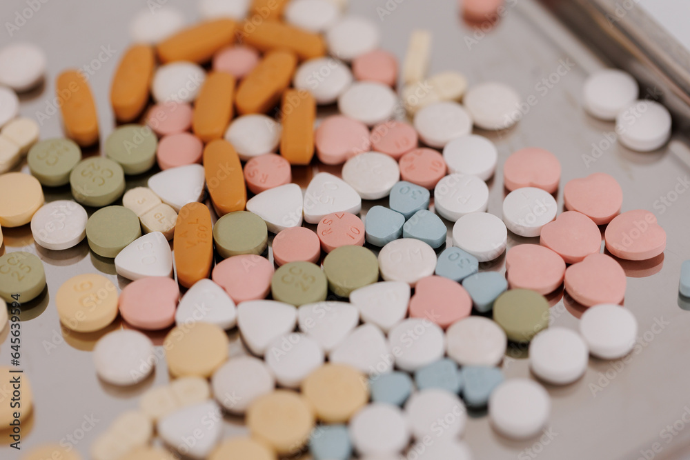 Macro Shot of colour Pills and Capsules During Production and Packing Process on Modern Pharmaceutical Factory. Tablet and Capsule Manufacturing Process. Close-up Shot of Medical Drug Production Line. Macro Shot of colour Pills and Capsules During Production and Packing Process on Modern Pharmaceutical Factory. Tablet and Capsule Manufacturing Process. Close-up Shot of Medical Drug Production Line.