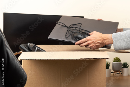 Foto Woman hands put old laptop computer in cardboard box with old used tech gadget devices for recycling