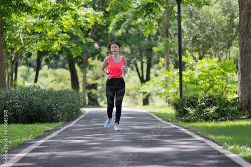 Asian female runner running on the street outdoors in the park