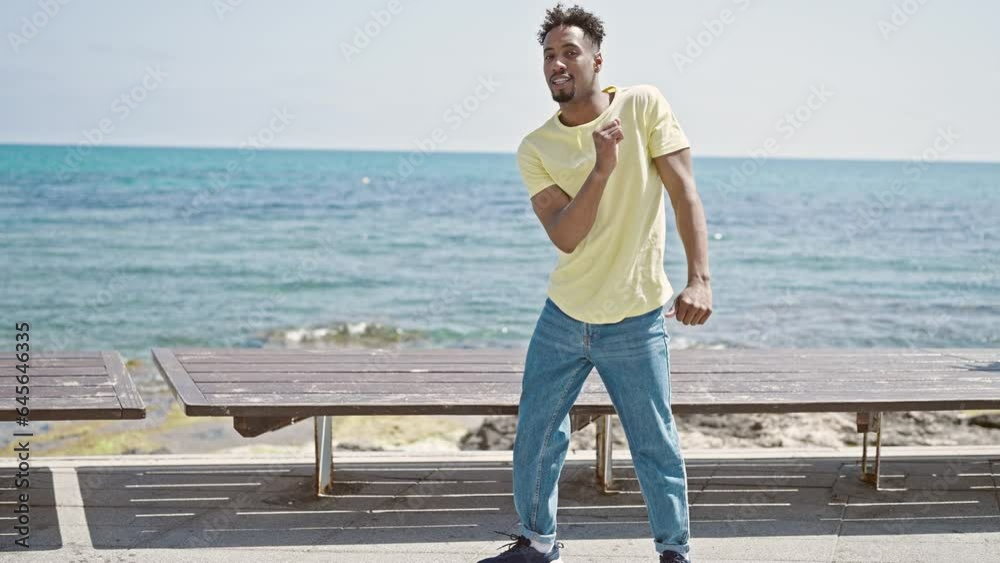 African american man smiling confident dancing at seaside African american man smiling confident dancing at seaside