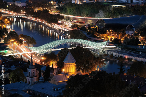 View of Bridge of Peace over Kura river and Zion Cathedral on autumn night. Tbilisi, Georgia.