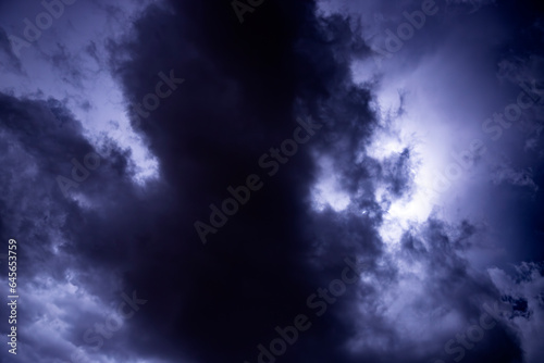 Fototapeta Naklejka Na Ścianę i Meble -  Ray. Storm. The sky is full of dark clouds in bad weather before a big storm rain. Light emission from the Edge of clouds. Zoom the surface of a Black haze at close range.