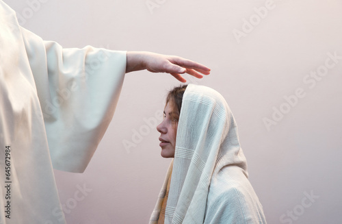Blessing hand above the head of a woman in a headscarf photo
