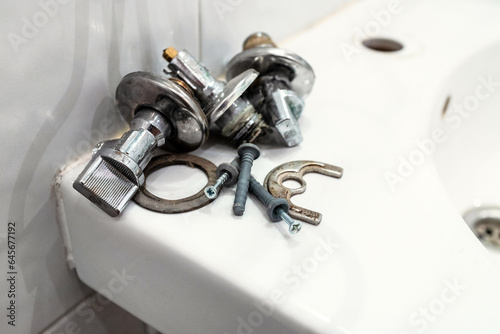 Wall Mural faulty ball valves and fixtures lie on edge of sink close up after removing the