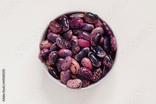 Фотография Round bowl with bright colorful scarlet runner beans on a white background