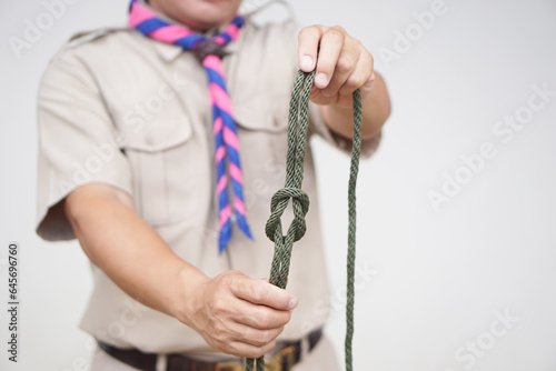 Tying rope knot pattern, demonstrated by scout teacher trainer. Concept, useful tying knot for many purposes in daily life. Tying knot rope teaching aid. Life skills with rope. 