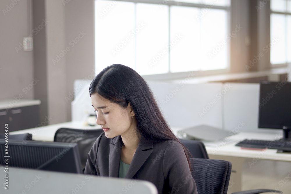 Serious beautiful Asian woman officer typing desktop computer while sitting at office desk. Concentrate female worker working at workplace, hardworking and busy office lady employee staff at office. Serious beautiful Asian woman officer typing desktop computer while sitting at office desk. Concentrate female worker working at workplace, hardworking and busy office lady employee staff at office.