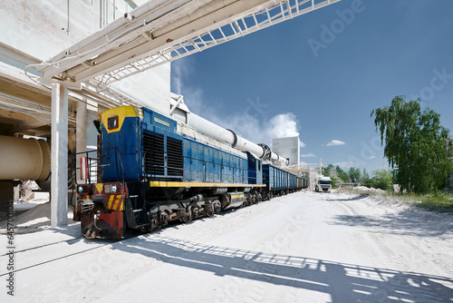 Locomotive moves cars across territory of silica plant