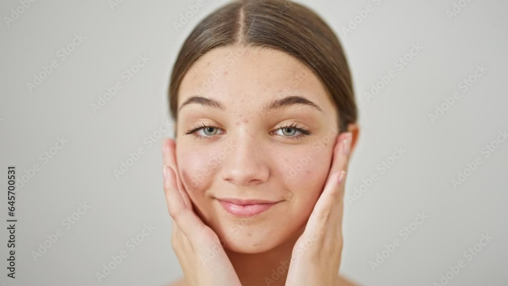 Young beautiful girl smiling confident massaging face over isolated white background Young beautiful girl smiling confident massaging face over isolated white background