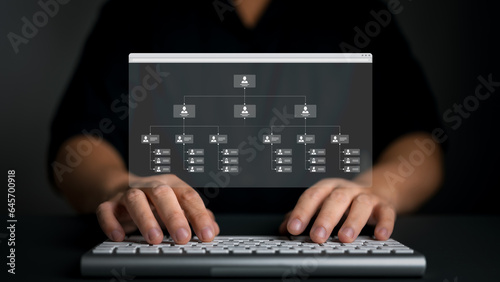 Man uses a keyboard with business process and workflow automation with flowchart screen. Organization chart with hierarchy structure of teams and employees in company. Business and technology concept.