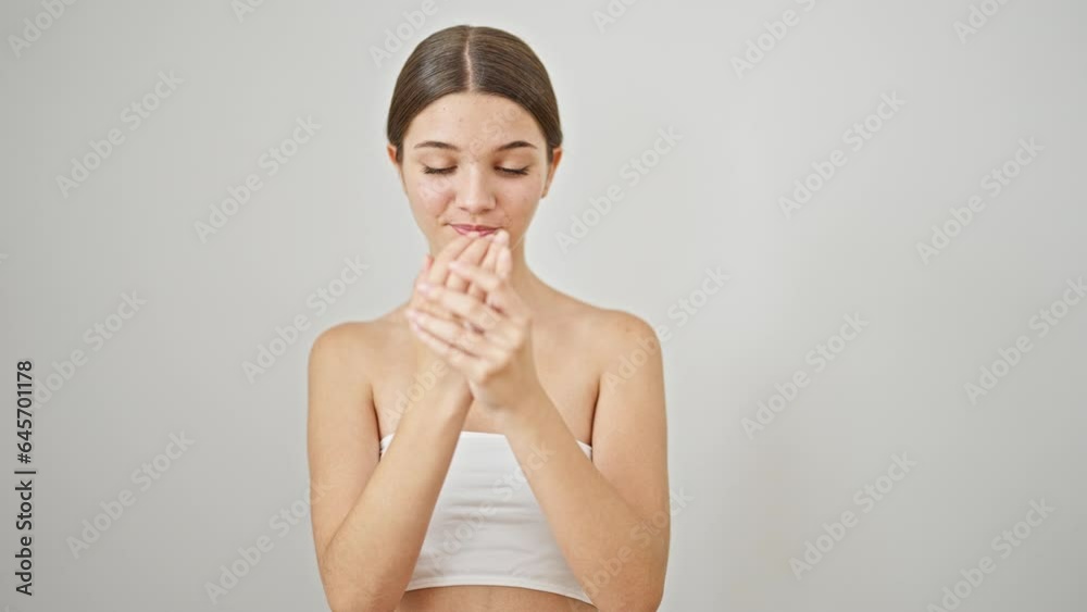 Young beautiful girl smiling confident applying skin lotion on hands over isolated white background Young beautiful girl smiling confident applying skin lotion on hands over isolated white background
