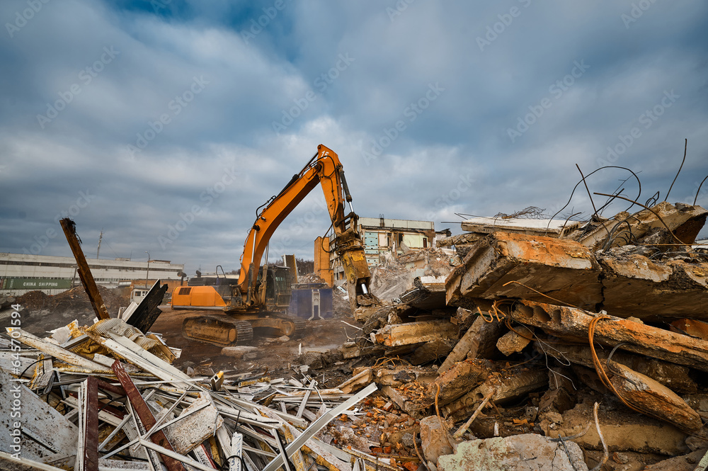 Fototapeta premium Excavator destroyer with hydraulic scissors cuts concrete