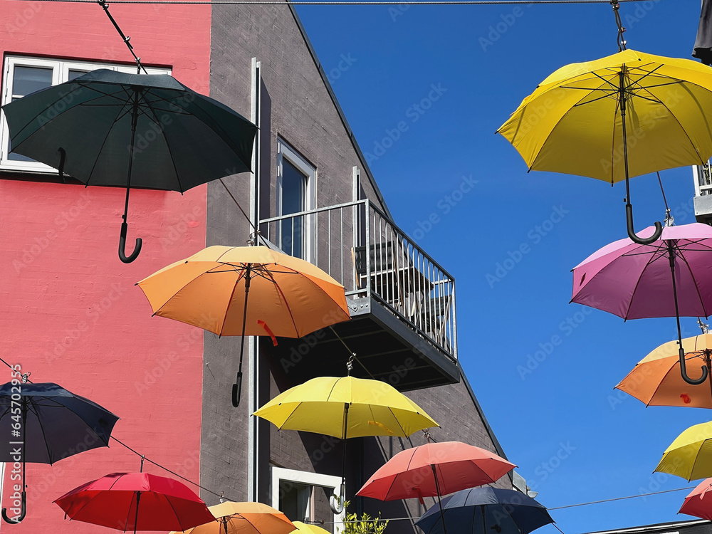  bunte Regenschirme hängen über einer Straße 