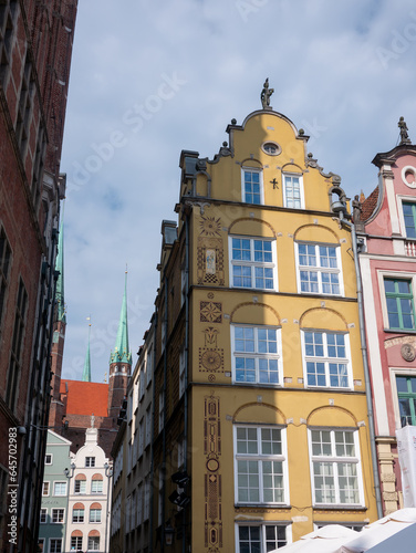 Yellow Gdańsk townhouse with St. Mary's Church visible in the background