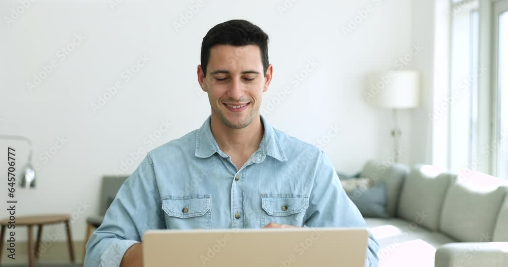 Smiling Hispanic guy sit at desk teach learner via videoconference on laptop show symbol with hands use gestures during sign language class. Man with disability make videocall by business, online work