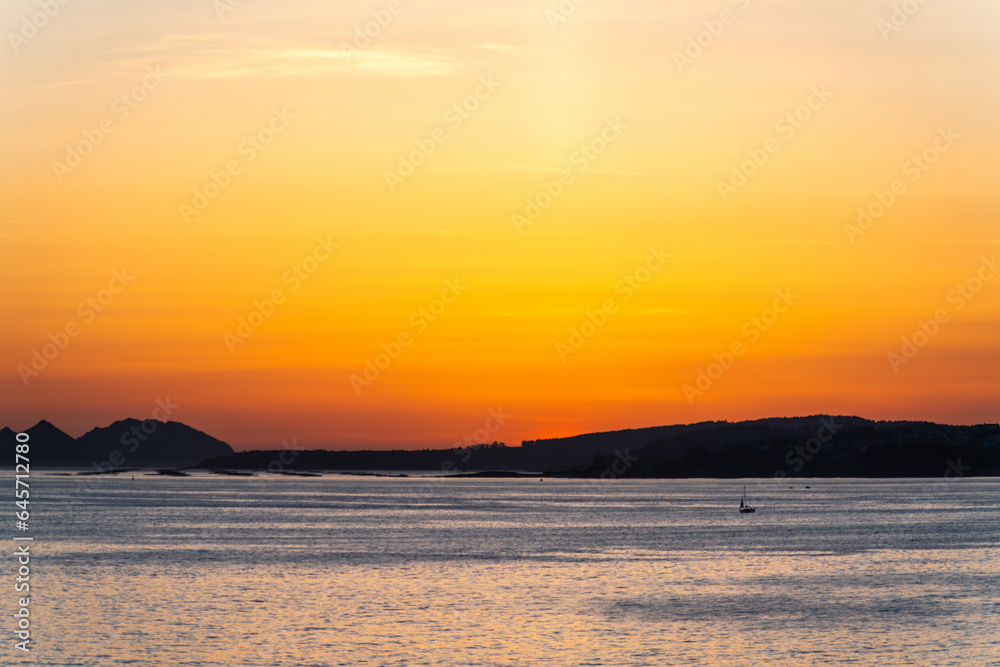 Boat sailing in the Ria de Vigo estuary at sunset.