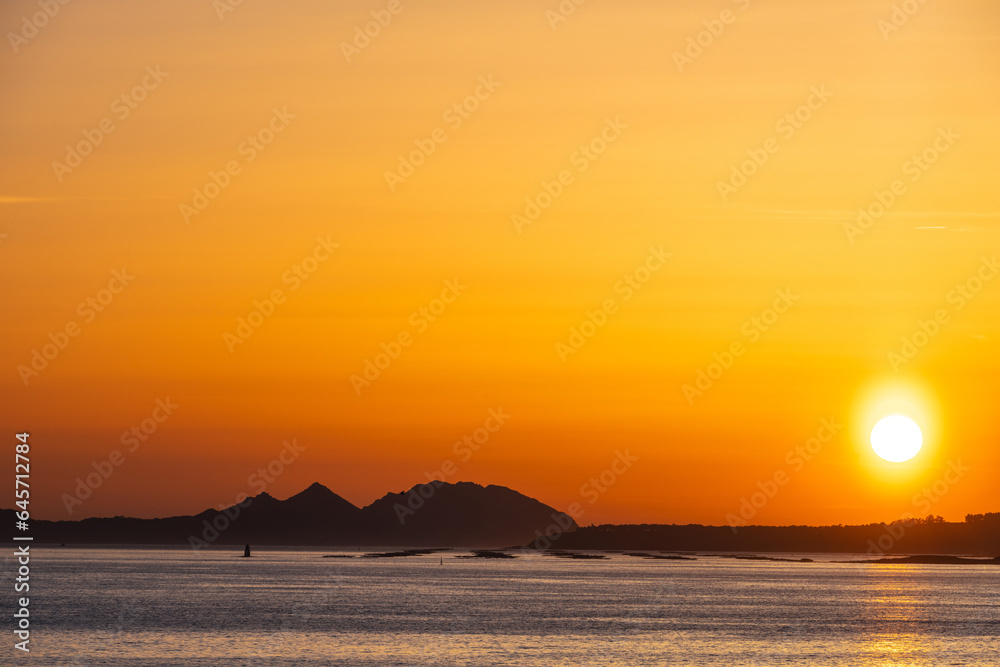 Orange sunset in the Ria de Vigo estuary with the Cies Islands in the background. Orange sunset in the Ria de Vigo estuary with the Cies Islands in the background.