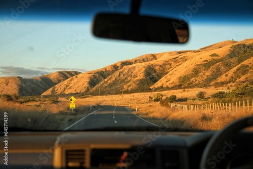 Inside car view road trip. The golden mountain landscape view.