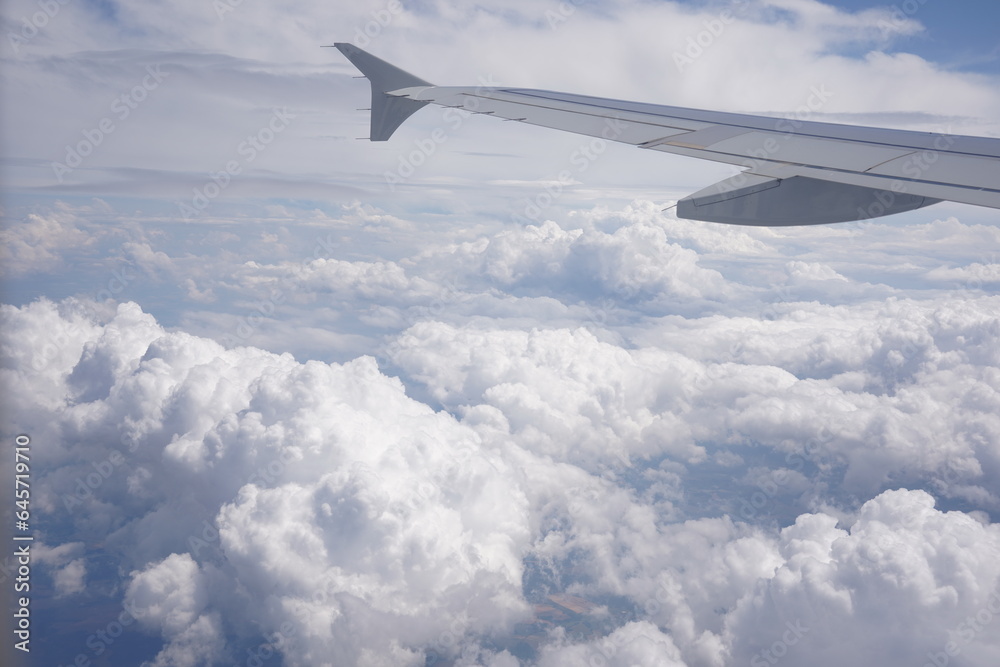 Aerial view on cloudy skies from airplane window