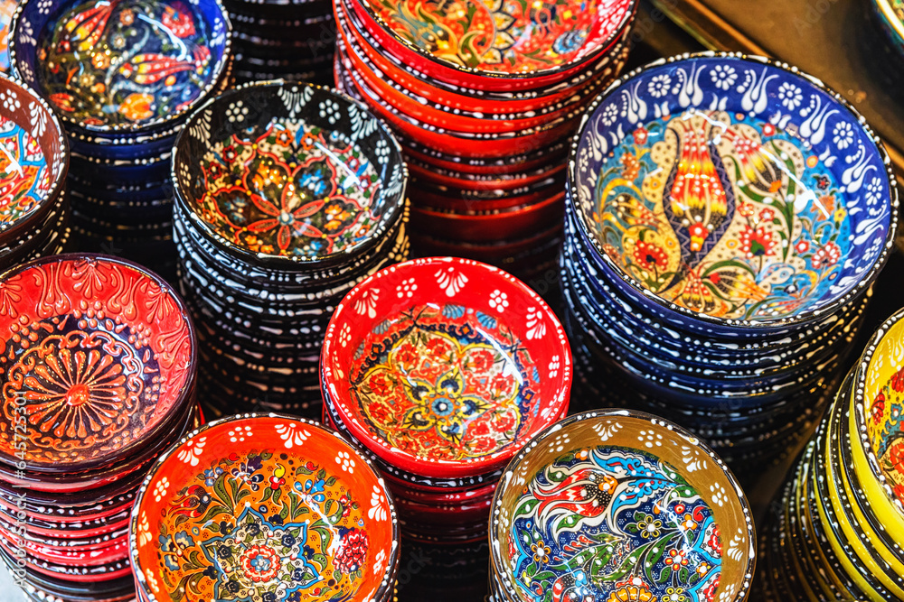Fototapeta premium Stack of classical traditional Turkish ceramics, handmade colorful dishes at the Istanbul street Bazaar. Istanbul, Turkey souvenirs. Selected focus, copy space
