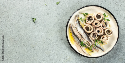 plate of canned anchovy fillets on a light background, Long banner format. top view