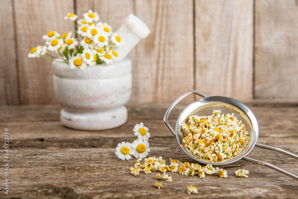 Dry chamomile flowers on a wooden table. Soothing chamomile tea. Herbal drink. flat layout. Space for text.Copy space.Medical prevention and immune concept. Folk alternative medicine. Dry chamomile flowers on a wooden table. Soothing chamomile tea. Herbal drink. flat layout. Space for text.Copy space.Medical prevention and immune concept. Folk alternative medicine.