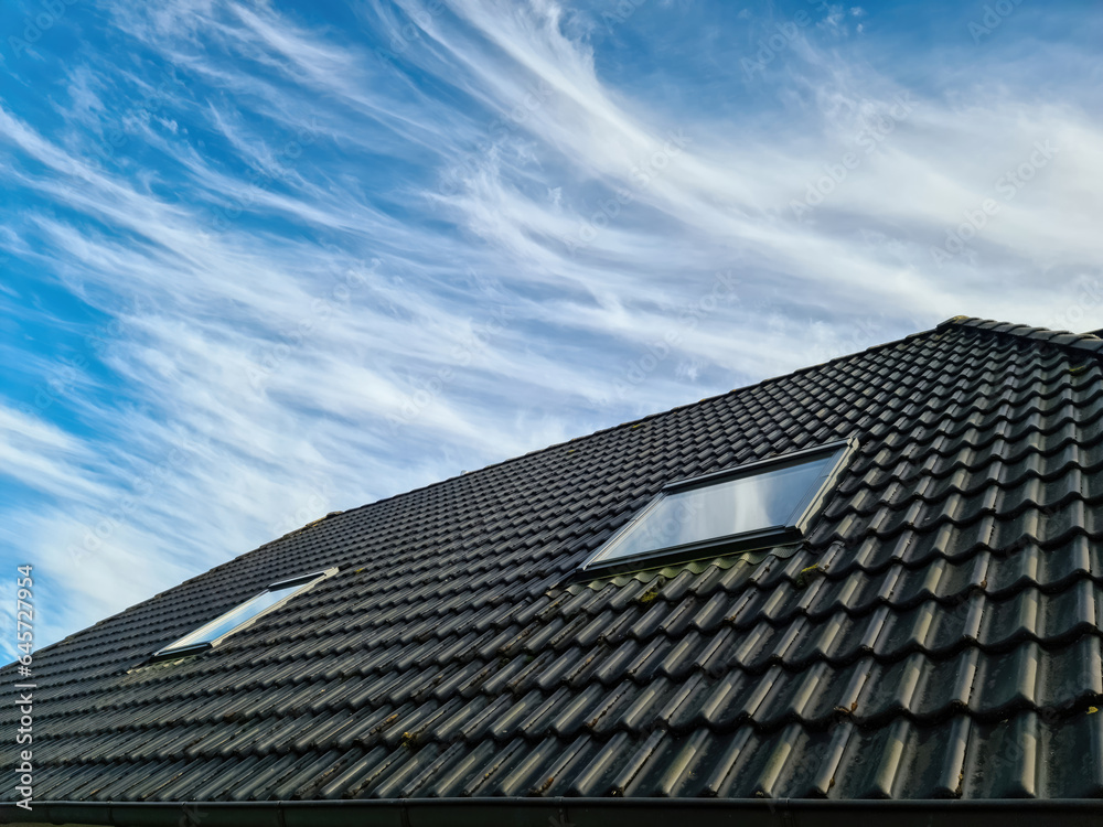 Open roof window in velux style with black roof tiles. Open roof window in velux style with black roof tiles.