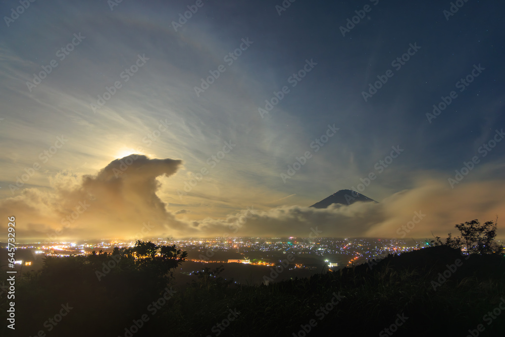 Obraz premium Giant cloud wave approaches Mt. Fuji on night of full moon