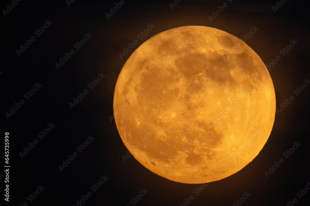 Moon looks orange and you can see the craters. Photography taken with a telescope. Moon looks orange and you can see the craters. Photography taken with a telescope.