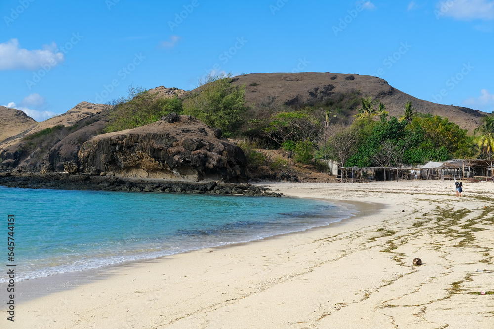 Kuta beach Lombok. Kuta Lombok is a small spread-out town in a beautiful bay lined by a long white sand beach, a beach with blue sky, a beach with sky and white sand, view of the beach in island