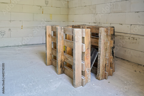 Wooden pallet at new house construction site, bare walls and floor in background