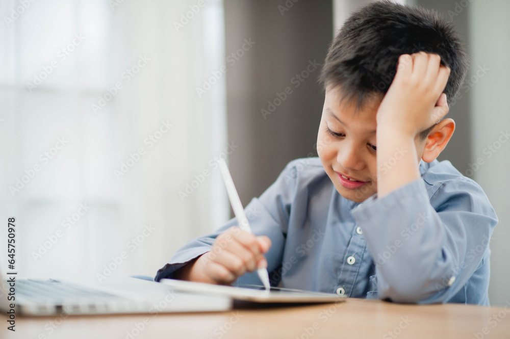 Little Asian boy student using computer laptop and tablet learning. Educational concept Social distancing, staying at home, presenting a modern educational way of life. Little Asian boy student using computer laptop and tablet learning. Educational concept Social distancing, staying at home, presenting a modern educational way of life.