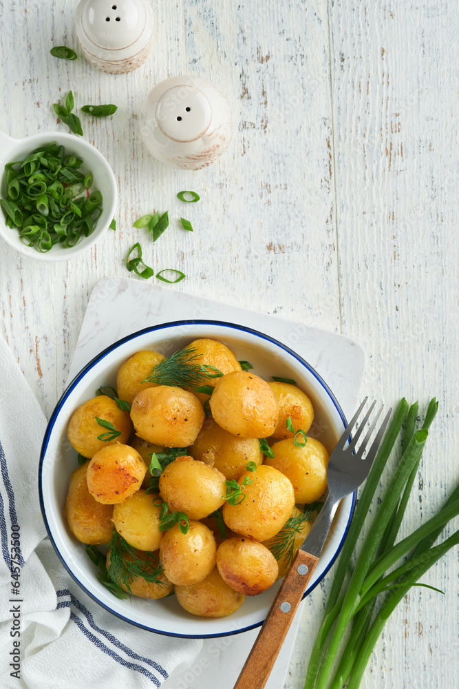 Boiled new or young potatoes with butter, fresh dill and onions in white bowl on white old rustic wooden background. Tasty new boiled potatoes. Top view. Boiled new or young potatoes with butter, fresh dill and onions in white bowl on white old rustic wooden background. Tasty new boiled potatoes. Top view.