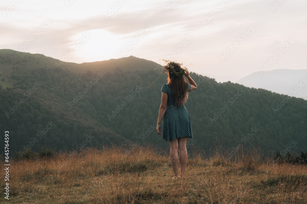 Carefree Happy Woman Enjoying Nature on grass meadow on top of mountain with sunrise. Beauty Girl Outdoor. Freedom concept.