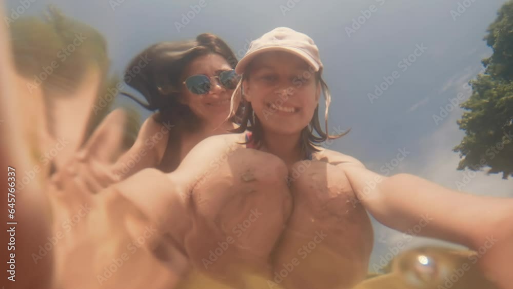 Pretty preteen girl and young woman at beach making selfie ...