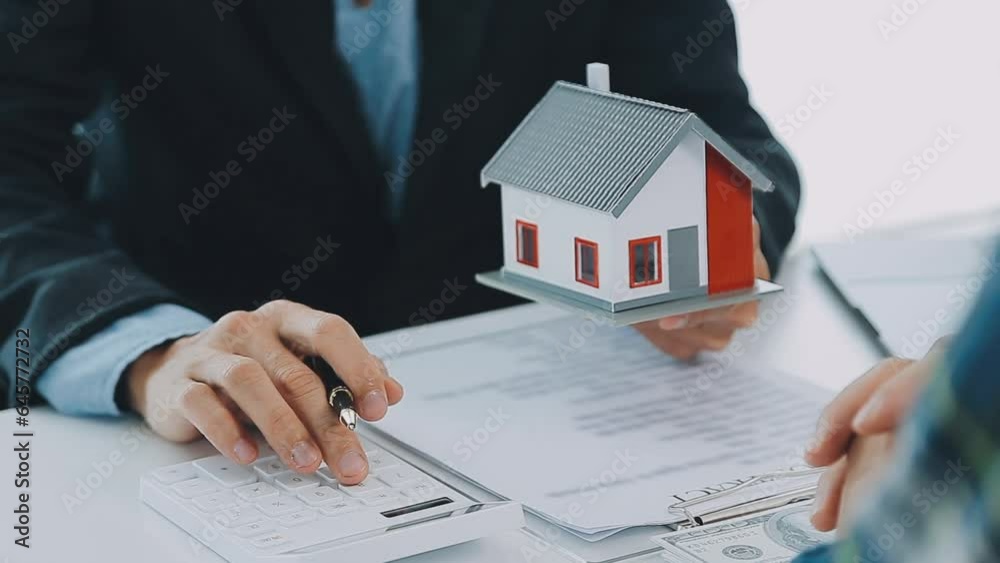 Real estate broker agent presenting and consult to customer to decision making sign insurance form agreement, buy and sell home model, concerning mortgage loan offer for and house insurance