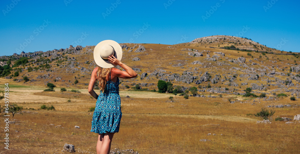Fototapeta premium Woman looking wilderness landscape- Lozere in France