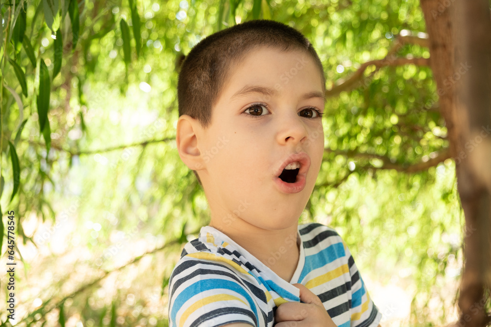 Portrait of a handsome six-year-old boy in a striped t-shirt in nature, a place for text to copy space Portrait of a handsome six-year-old boy in a striped t-shirt in nature, a place for text to copy space