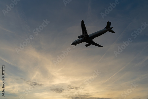 silhouette of an airplane against the cloudy evening sky