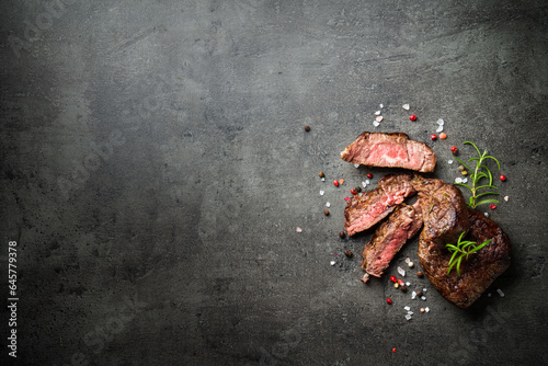 Fototapeta Naklejka Na Ścianę i Meble -  Meat steak on black backgound. Cutting Beef medallions with spices and herbs. Close up.