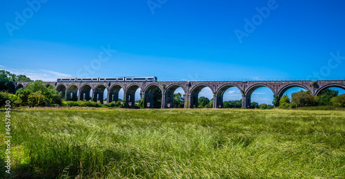 A panorama view of a train crossing the Souldern viaduct in Oxfordshire, UK in summertime photo