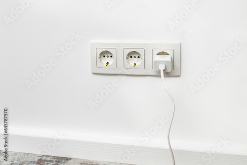 White triple outlet on white wall