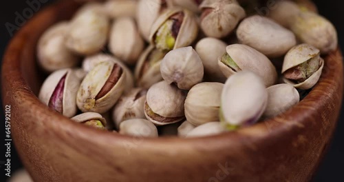 sprinkle pistachios nuts on the table, a large number of salty and crispy pistachios close-up